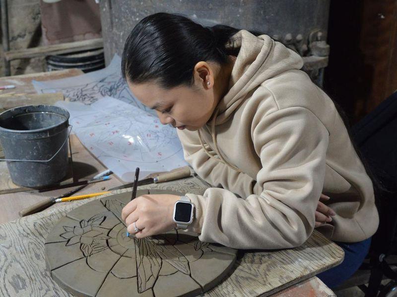 Student creating a ceramic tile